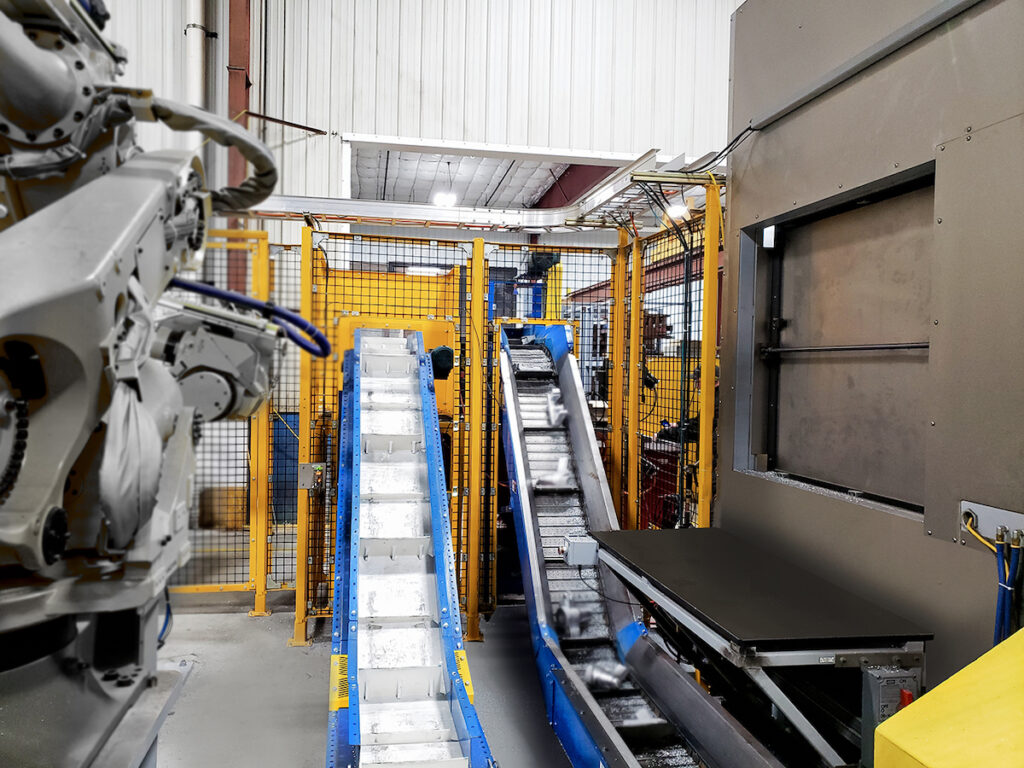 Interior of manufacturing facility with robots and conveyors moving materials in a secure area